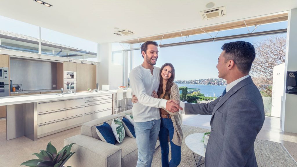 Real estate agent with couple in luxury home.